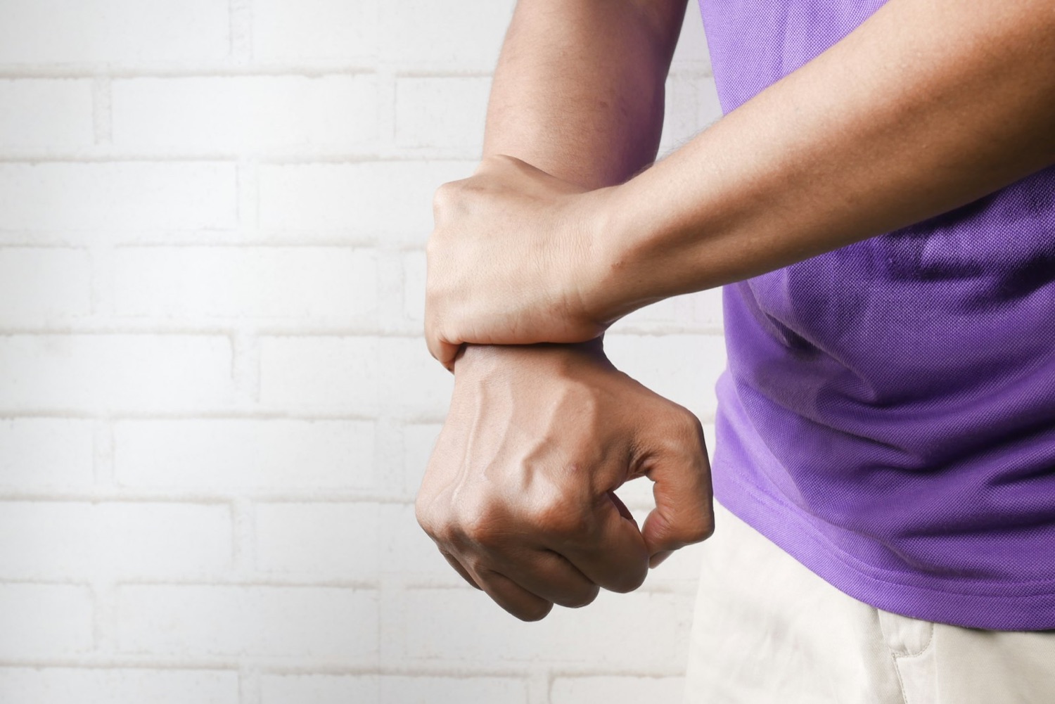 Driver wearing a wrist support brace to keep the wrist in a neutral position and ease carpal tunnel